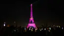Foto yang diambil dari alun-alun Trocadero ini menunjukkan Menara Eiffel yang diterangi dengan warna merah muda di Paris pada tanggal 1 Oktober 2023. (Dimitar DILKOFF/AFP)