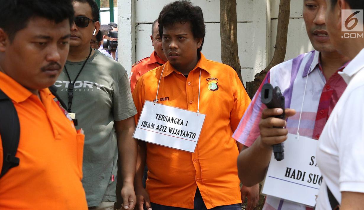Tersangka insiden penembakan peluru nyasar di ruangan anggota DPR, IAW, menjalani proses rekonstruksi Lapangan Tembak Senayan, Jakarta, Jumat (19/10). IAW dan RMY merupakan Pegawai Negeri Sipil Kementrian Perhubungan. (Liputan6.com/Immanuel Antonius)
