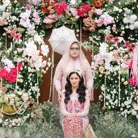 Sebelum prosesi siraman dimulai, Ochi tampak anggun mengenakan kebaya Sunda berwarna pink pastel yang dipadukan dengan kemben merah. [@thepotomoto].