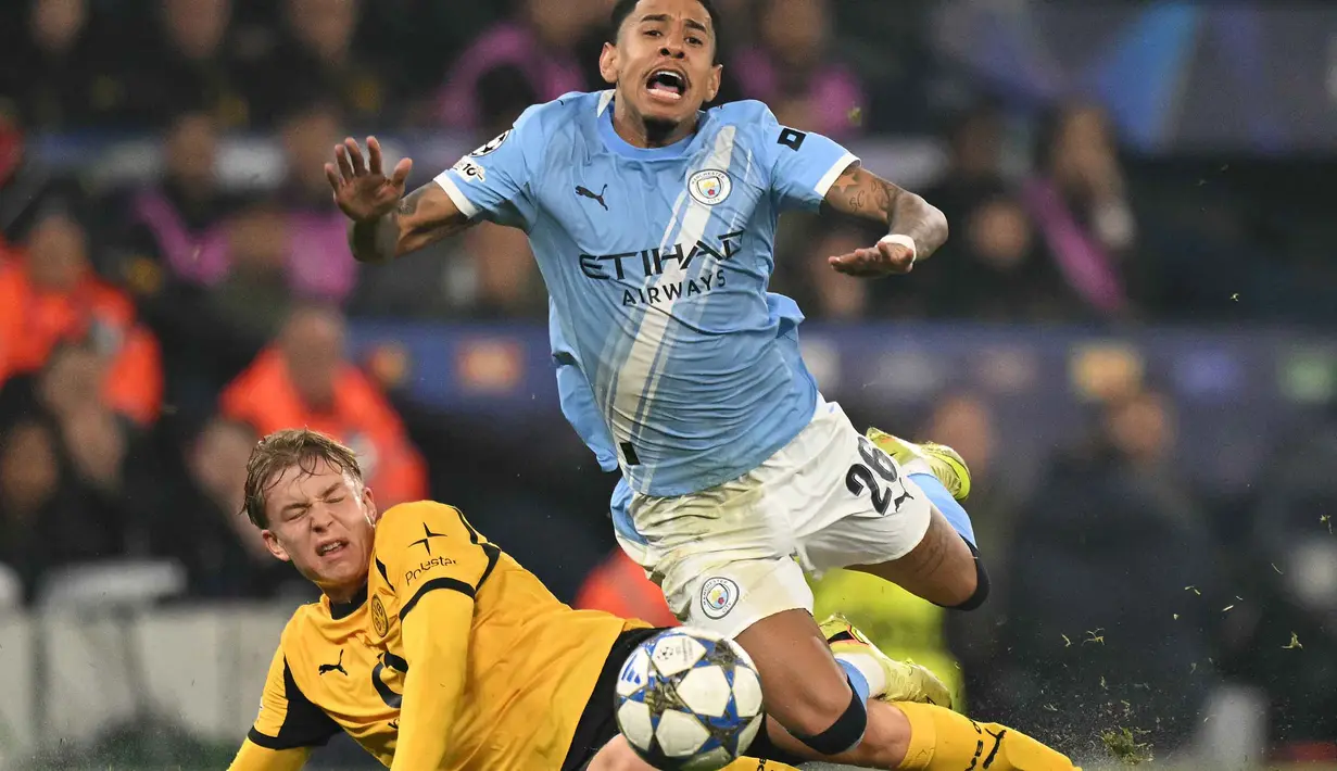 Di babak kedua, dominasi City semakin tak terbendung. Tampak dalam foto, bek Dortmund asal Swedia, Daniel Svensson mengadang gelandang Manchester City asal Brasil Savinho dalam pertandingan lanjutan fase liga Liga Champions 2025/2026 antara Manchester City dan Borussia Dortmund di Stadion Etihad, Manchester, Inggris barat laut, pada 5 November 2025 waktu setempat atau Kamis (6/11) dini hari WIB. (Oli SCARFF/AFP)