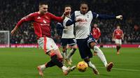 Bek Manchester United asal Portugal #20, Diogo Dalot (kiri), berebut bola dengan bek Tottenham Hotspur asal Inggris #24, Djed Spence (kanan), selama pertandingan Liga Primer Inggris antara Tottenham Hotspur dan Manchester United di Stadion Tottenham Hotspur di London, pada 16 Februari 2025. (Glyn KIRK/AFP)
