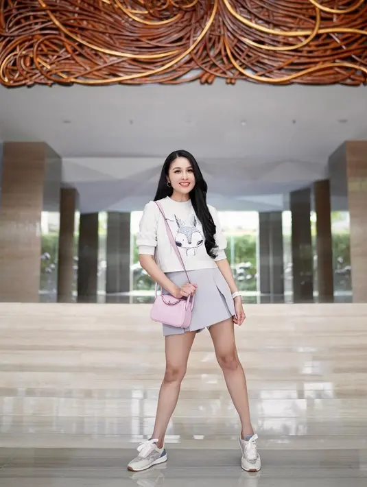 Sweater bergambar menjadi fashion item klop rok mini bagi Sandra Dewi untuk menyalurkan inner child-nya. [@sandradewi]