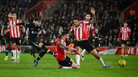Gelandang Liverpool asal Inggris Harvey Elliott menembak dan mencetak gol kedua timnya selama pertandingan sepak bola perempat final Piala Liga Inggris antara Southampton dan Liverpool di Stadion St Mary di Southampton, Inggris selatan, pada 18 Desember 2024.JUSTIN TALLIS / AFP