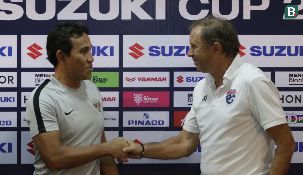 Pelatih Timnas Indonesia, Bima Sakti, bersalaman dengan pelatih Thailand, Milovan Rajevac, saat jumpa pers di Stadion Rajamangala, Bangkok, Jumat (16/11). Indonesia akan melawan Thailand pada laga Piala AFF 2018. (Bola.com/M. Iqbal Ichsan)