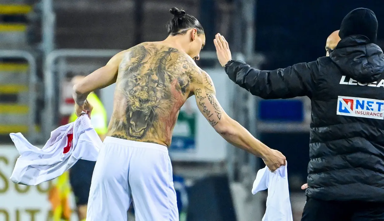 Striker AC Milan, Zlatan Ibrahimovic, menukar jersey saat melawan Cagliari pada laga Liga Italia di Sardegna Arena, Senin (19/1/2021). AC Milan menang dengan skor 2-0. (AFP/Alberto Pizzoli)