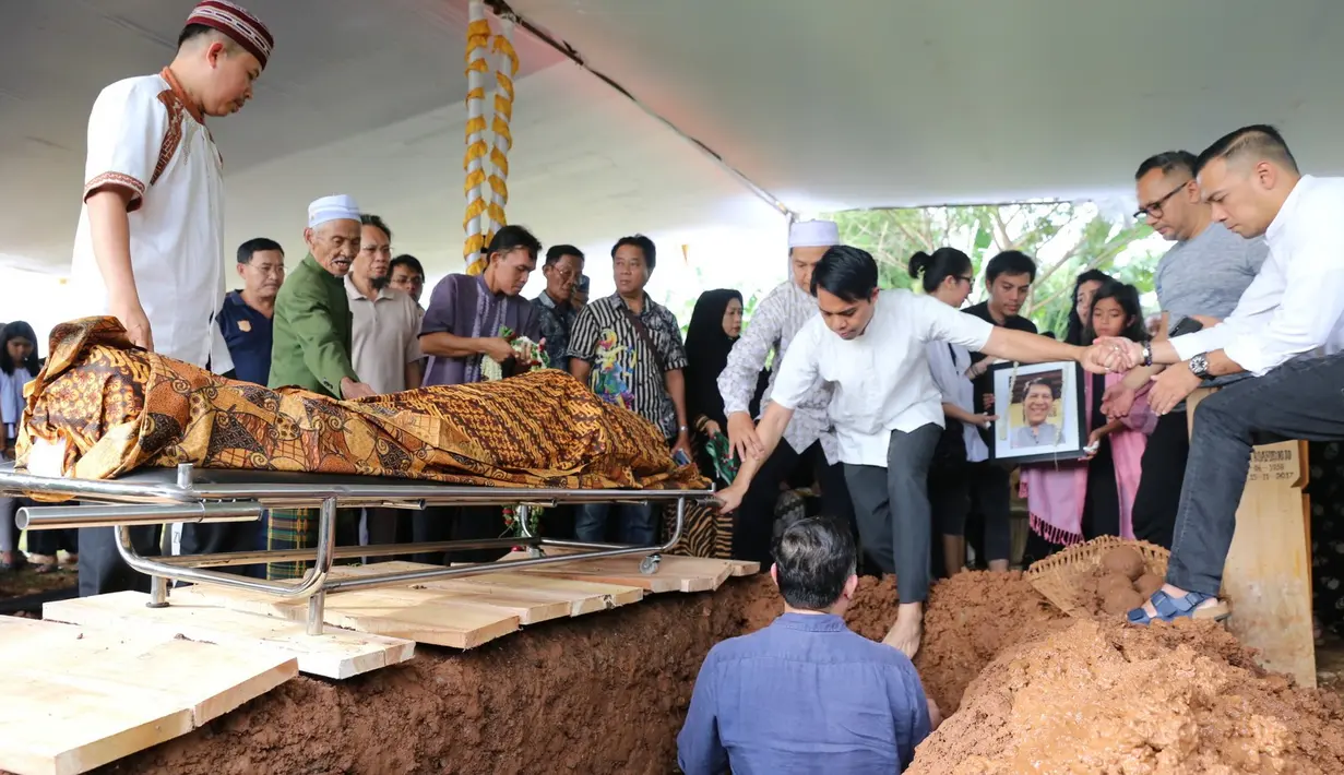Selama pemakaman berlangsung Novita Angie tak kuasa menahan sedihnya. Di balik kacamatanya, air mata terus berderai dari pelupuknya. Mengenakan busana hitamnya, Novita Angie terus mengamati jenazah ayahanda. (Daniel Kampua/Bintang.com)
