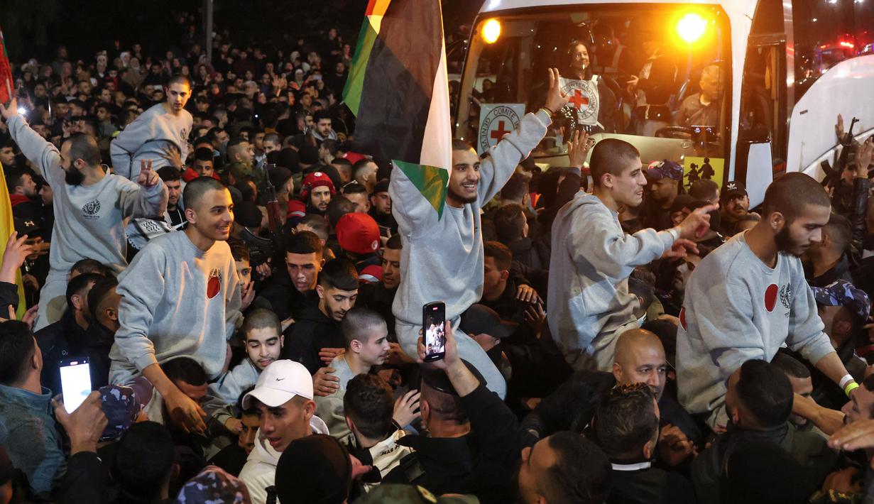 Kerumunan orang menyambut warga Palestina yang sebelumnya dipenjara oleh Israel saat tiba dalam konvoi Palang Merah ke Ramallah di Tepi Barat yang diduduki pada 30 Januari 2025. (Ahmad GHARABLI/AFP)