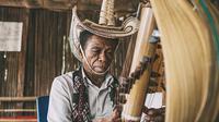 Pria memainkan alat musik Sasando. (Liputan6.com/Wikimedia Commons/Fakhri Anindita)