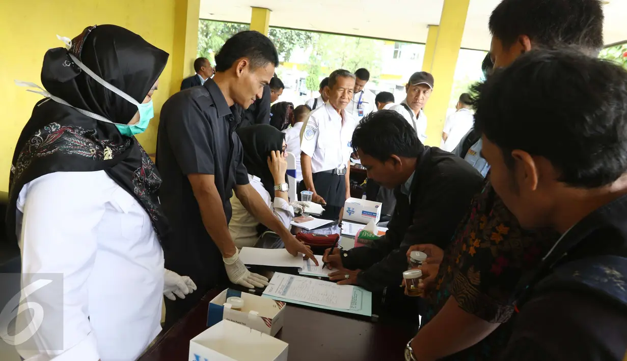 Sejumlah karyawan PPD mengisi data saat melakukan tes urine di Pool Bus Perum PPD di Tangerang Selatan, Senin (20/3). Sosialisasi dan test urine oleh digelar oleh Badan Narkotika Nasional (BNN) RI. (Liputan6.com/Helmi Afandi)
