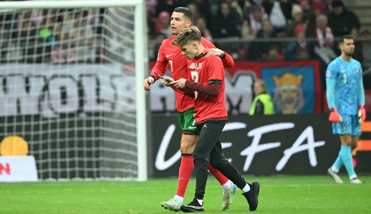Cristiano Ronaldo memberi kesempatan suporter untuk berswafoto sambil berjalan beriringan menuju ke arah pinggir lapangan. (Sergei GAPON/AFP)