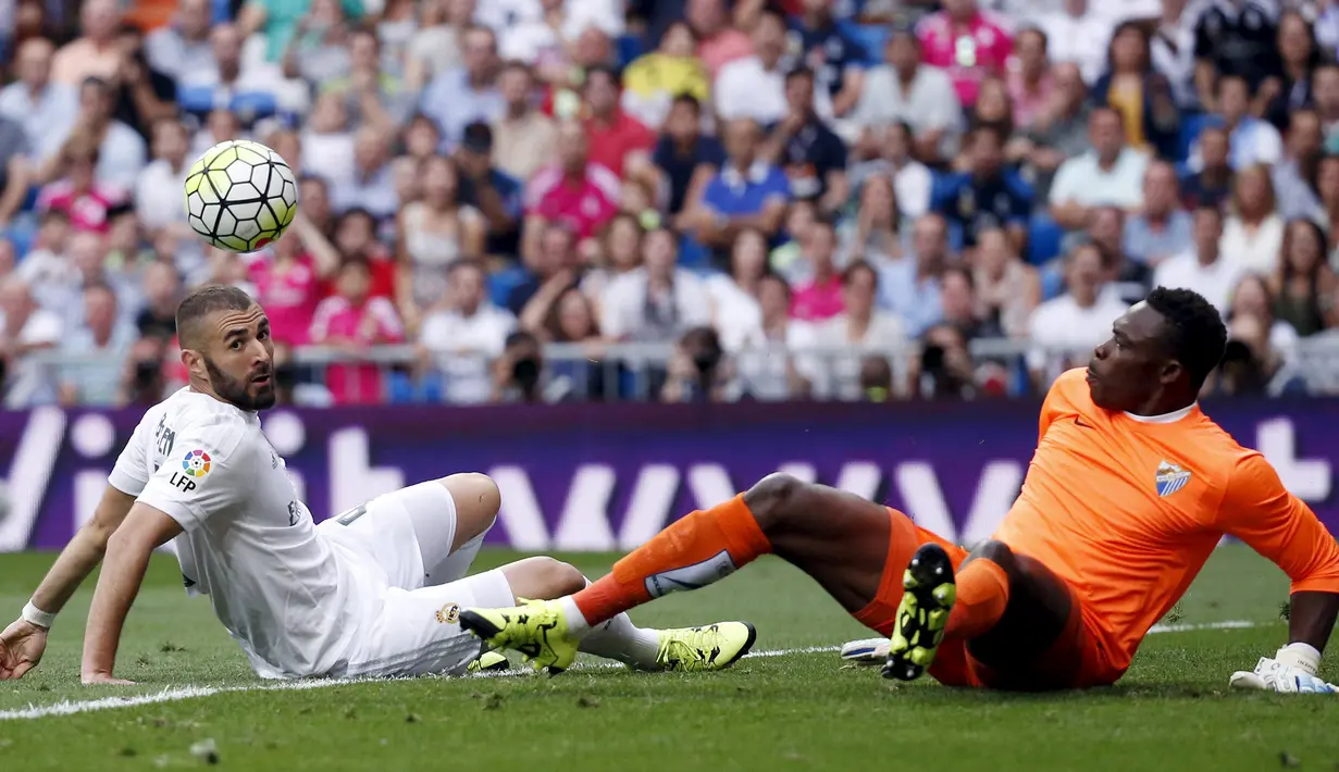 Kiper Malaga, Idriss Kameni (kanan) berusaha menghalau bola dari kejaran penyerang Karim Benzema pada Liga Spanyol di Santiago Bernabeu, Madrid, (26/9/2015). Madrid bermain imbang atas malaga dengan skor 0-0. (AFP PHOTO/PIERRE-PHILIPPE Marcou)