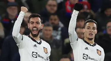 Gelandang Manchester United (MU) Bruno Fernandes (kiri) merayakan dengan rekannya setelah mencetak gol pertama timnya ke gawang Crystal Palace pada pada matchday 19 Liga Inggris di Stadion Selhurst Park, London, Kamis dini hari WIB (19/1/2023). Nasib kurang beruntung dirasakan MU setelah ditahan imbang Crystal Palace 1-1. (ADRIAN DENNIS / AFP)