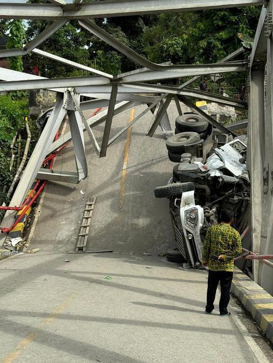 Petugas melihat kondisi jembatan di Desa Busui Kecamatan Batu Sopang, Kabupaten Paser, Kalimantan Timur yang rubuh saat dilintasi truk tangki bermuatan semen, Kamis dini hari (16/1/2025). (Dokumentasi Dinas Perhubungan Paser)