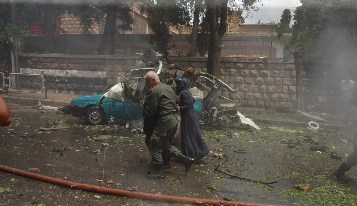 Seorang tentara Suriah membantu mengevakuasi warga setelah roket pemberontak menghantam rumah Sakit al- Dabit di kota Aleppo, Selasa (3/5). Serangan tersebut menewaskan enam warga sipil dan puluhan lainnya luka-luka. (SANA/Handout via REUTERS)