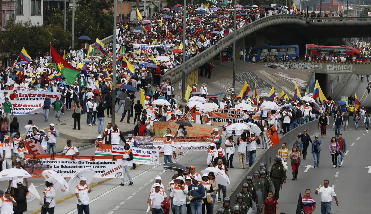 Ribuan guru melakukan aksi unjuk rasa di Bogota, Kolombia, Selasa (6/6). Para guru yang telah mogok selama 27 hari terakhir ini menuntut peningkatan dan perbaikan upah. (AP Photo / Fernando Vergara)