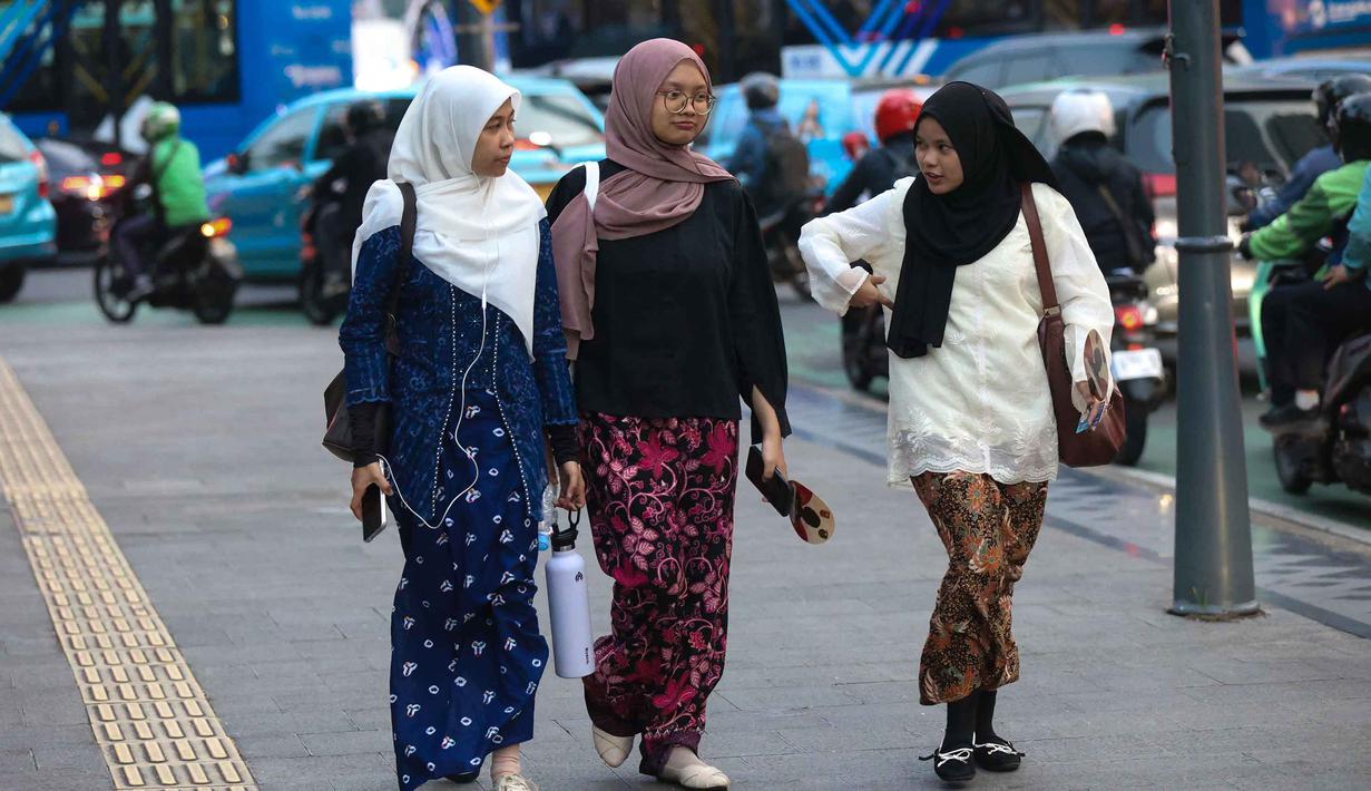 Raden Ajeng Kartini berjuang melalui pemikiran yang dituangkan dalam surat-suratnya yang didokumentasikan dalam buku berjudul "Door Duisternis tot Licht" atau Habis Gelap Terbitlah Terang. Tampak dalam foto, beberapa perempuan mengenakan kebaya saat melintas di sekitar kawasan Bundaran Hotel Indonesia, Jakarta, Selasa (21/4/2026). (Kapanlagi.com/Budy Santoso)