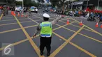 Seorang petugas polisi mengalihkan arus di kawasan Sarinah, Jakarta, Jumat (4/11). Pengalihan ini dilakukan karena aksi 4 November yang memadati tiga titik, yaitu di kantor Bareskrim Polri Balai Kota DKI, dan Istana Negara. (Liputan6.com/Angga Yuniar)