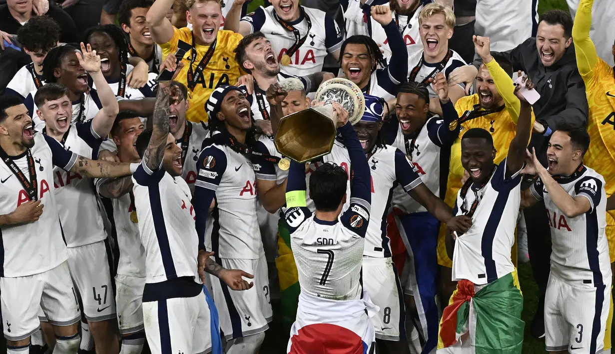 Son Heung-min (tengah) mengangkat trofi untuk merayakan kemenangan bersama para pemain Tottenham setelah menjuarai final Liga Europa 2024/2025 di Stadion San Mames, Bilbao, Spanyol, Kamis (22/05/2025) WIB. Tottenham menang dengan skor 1-0 atas Manchester United. (AFP/Ander Gillenea)