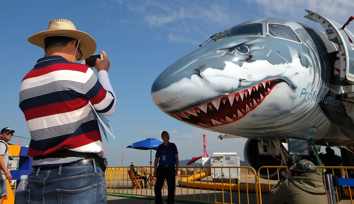 Seorang pria mengambil foto Jet Komersial Embraer E190-E2 saat ditampilkan dalam Pameran Penerbangan dan Antariksa Internasional ke-12 China atau Airshow China 2018 di Kota Zhuhai, Provinsi Guangdong, Rabu (7/11). (AP Photo/Kin Cheung)