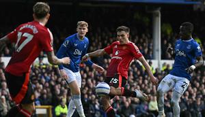 Gelandang Manchester United (MU), Manuel Ugarte, melepaskan tembakan yang berbuah gol kedua timnya kala bertandang ke Goodison Park, markas Everton, pada laga pekan ke-26 Premier League 2024/2025, Sabtu (22/2/2025) malam WIB. MU membawa pulang satu poin setelah bermain imbang 2-2 dengan The Toffees. (Paul ELLIS / AFP)