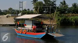 Perahu eretan mengangkut sebuah mobil menyebrangi Sungai Citarum di Muara Gembong, Bekasi, Rabu, (29/7/2015). Kendaraan yang menyebrang menggunakan perahu eretan dikenakan biaya Rp.20.000 bagi mobil dan Rp 2.000 motor. (Liputan6.com/Johan Tallo)