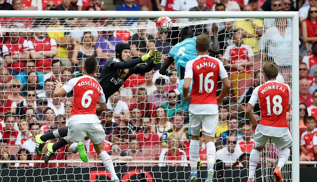 Cheikhou Kouyate menaklukkan kiper Arsenal, Petr Cech, untuk mencetak gol pertama West Ham dalam pertandingan di Stadion Emirates, London. Minggu (9/8/2015). (Action Images via Reuters/Tony O'Brien)