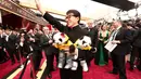 Ada yang menarik perhatian dalam acara Oscar tersebut. Aktor laga, Jackie Chan hadir dengan membawa dua boneka panda. Sontak, kehadirannya menarik perhatian para awak media dan tamu undangan lain. (AFP/Bintang.com)