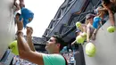 Petenis asal Kanada Milos Raonic membubuhkan tanda tangan di topi penggemarnya setelah memenangkan pertandingan putaran kedua Australia Terbuka melawan petenis Jerman Dustin Brown di Melbourne, 17 Januari 2017. (AP Photo/Aaron Favila)
