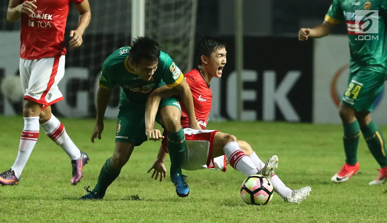 Gelandang Persija, Sutanto terjatuh saat berebut bola dengan pemain Sriwijaya FC pada lanjutan Liga 1 Indonesia di Stadion Wibawa Mukti, Cikarang Kab Bekasi, Jumat (16/6). Persija unggul 1-0. (Liputan6.com/Helmi Fithriansyah)