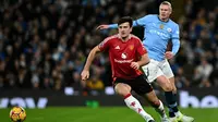 Bek Manchester United asal Inggris #05, Harry Maguire, berlari mengejar bola dari penyerang Manchester City asal Norwegia #09 Erling Haaland dalam pertandingan&nbsp;Premier League antara Manchester City dan Manchester United di Stadion Etihad, Manchester, Inggris barat laut, pada 15 Desember 2024. (Paul ELLIS/AFP)