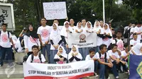 Sejumlah pelajar berfoto bersama sambil memegang spanduk saat menggelar aksinya di depan Istana Presiden, Jakarta, Sabtu (25/2). Dalam aksinya para siswa-siswi pelajar tersebut menolak jadi target dari iklan rokok. (Liputan6.com/Helmi Afandi)