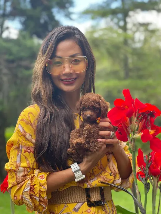 Berfoto bersama Pixie Bell, Mini Toy Poodle kesayangannya, Indah Kalalo nampak anggun dengan dress print floral. Dress berwarna kuning tersebut tampak selaras dengan warna kulit Indah Kalalo yang membuatnya terlihat anggun dengan gaun sederhana. (Instagram/indahkalalo)