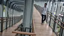 Pejalan kaki melintas di jembatan penyeberangan orang (JPO) Bundaran Senayan, Jakarta, Senin (21/1). JPO Bundaran Senayan mengedepankan konsep minimalis modern. (Liputan6.com/Faizal Fanani)