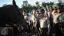 Kapolri Jenderal Tito Karnavian menyapa seorang pasukan polisi berkuda saat Apel Gelar Pasukan Operasi Lilin Jaya 2017 di Lapangan Silang Monas, Jakarta, Kamis (22/12). (Liputan6.com/Faizal Fanani)