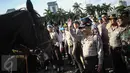 Kapolri Jenderal Tito Karnavian menyapa seorang pasukan polisi berkuda saat Apel Gelar Pasukan Operasi Lilin Jaya 2017 di Lapangan Silang Monas, Jakarta, Kamis (22/12). (Liputan6.com/Faizal Fanani)