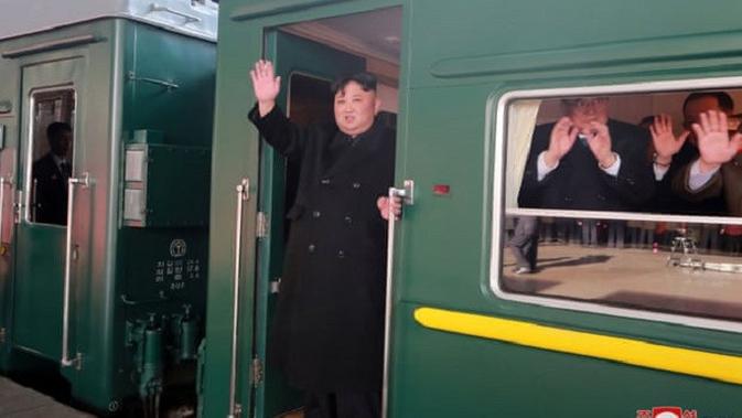Pemimpin Korea Utara, Kim Jong-un melambaikan tangannya dari dalam kereta yang ia tumpangi, saat hendak berangkat ke Hanoi, Vietnam, untuk bertemu dengan Donald Trump. (KCNA)