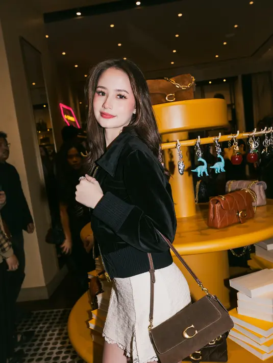 Sementara itu, Jasmine Meijers menghadirkan gaya yang lebih manis namun tetap chic. Ia memadukan cropped jacket hitam dengan rok tekstur ringan, lalu melengkapi look dengan tas Coach bernuansa earthy tone.  [Dok/KANMO GROUP].