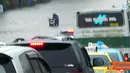 Seorang pengendara motor terjebak di tengah genangan banjir.