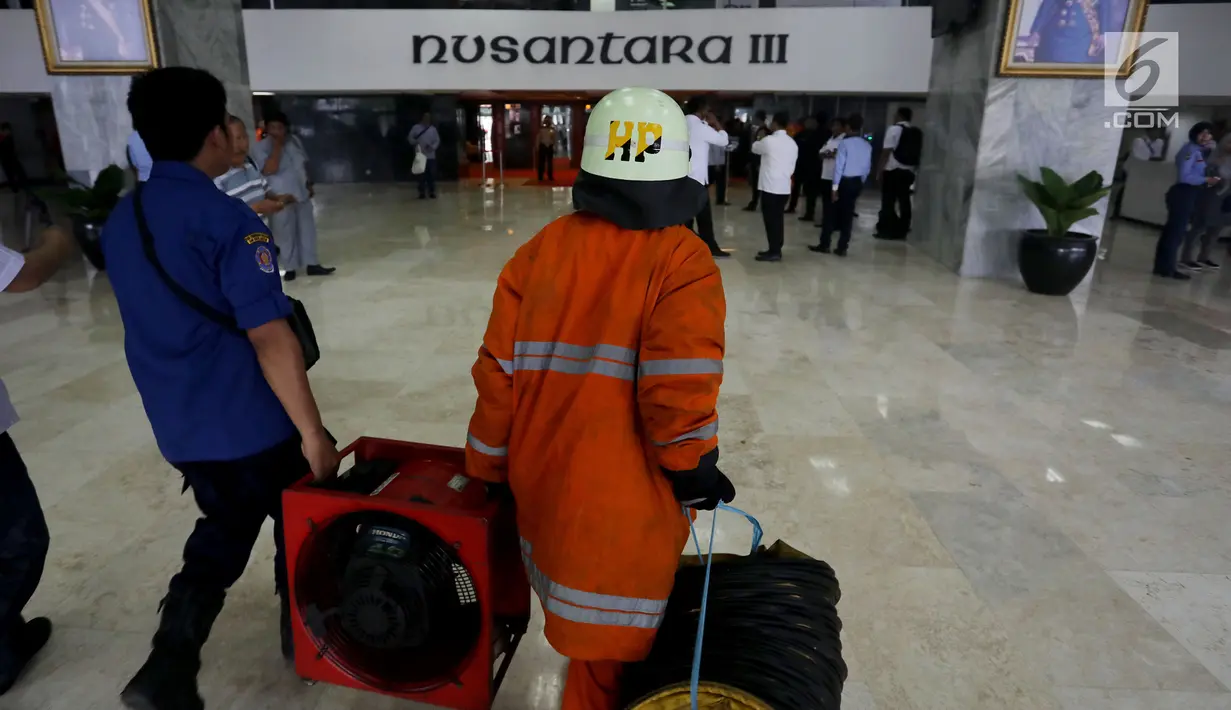 Petugas membawa alat pemadam kebakaran menuju sebuah ruangan lantai dua Gedung Nusantara III, Kompleks Parlemen, Senayan, Jakarta, Selasa (14/11). Kebakaran melanda Ruangan kelompok kerja (Pokja) Sipil di gedung DPR. (Liputan6.com/Johan Tallo)