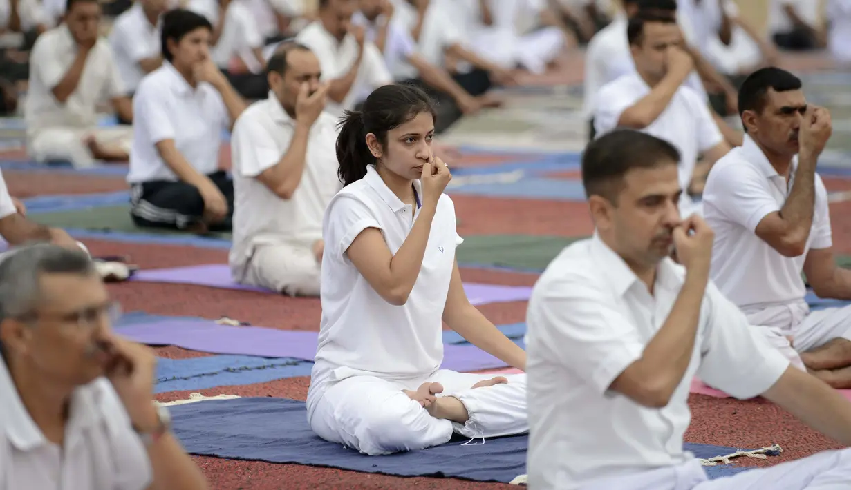 Personel Angkatan Darat India saat mengikuti senam yoga di Ahmedabad, India, Senin (20/6). Kegiatan ini untuk memeriahkan perayaan Hari Yoga Internasional. (AFP PHOTO/Sam Panthaky)