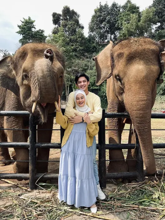 Dinda Hauw tampil cantik dengan tiered dress warna biru dipadukan knit cardigan dan pashmina putih dalam momen liburannya ke Lembang Park Zoo [Foto: IG/dindahw].