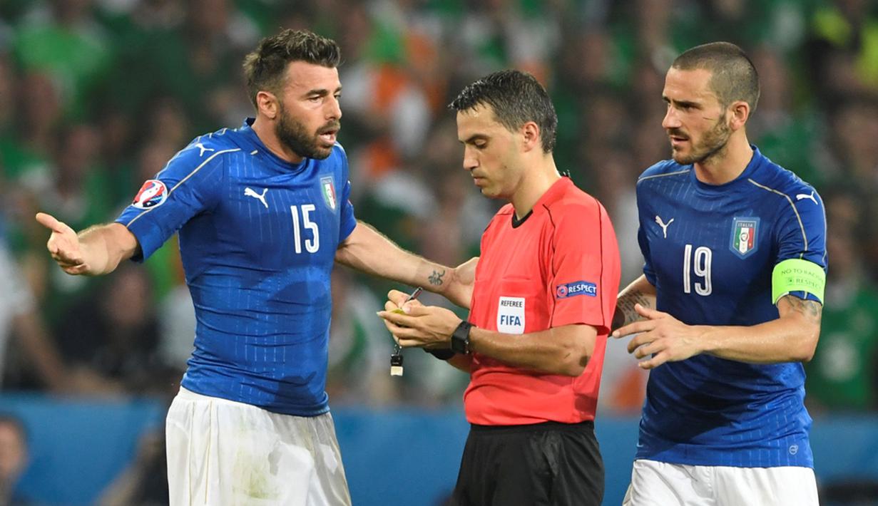 Pemain Italia, Leonardo Bonucci dan Andrea Barzagli, memprotes wasit Ovidiu Hategan pada laga Grup E Piala Eropa 2016 di Stade Pierre Mauroy, Lille, Kamis (23/6/2016) dini hari WIB. (AFP/Miguel Medina)