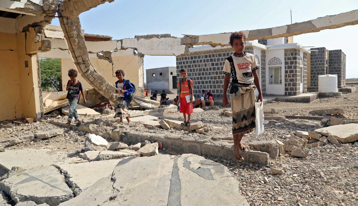 Anak-anak Yaman menghadiri kelas di luar ruangan sebuah sekolah yang rusak parah pada hari pertama tahun ajaran baru di provinsi barat Yaman yang dilanda perang Hodeida, Senin (17/10/2022). UNICEF memperkirakan bahwa lebih dari dua juta anak telah putus sekolah di Yaman, peningkatan hampir setengah juta sejak perang pecah pada 2015. (Foto oleh Khaled ZIAD / AFP).