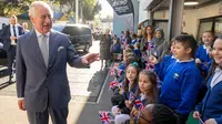 Raja Charles III disambut saat ia tiba untuk bertemu dengan anggota dan staf asosiasi "Project Zero", sebuah organisasi yang didedikasikan untuk melibatkan kaum muda dalam kegiatan positif, mempromosikan inklusi sosial dan memperkuat kohesi masyarakat, selama kunjungan pusat di Walthamstow, di London timur, pada 18 Oktober 2022. (Paul Grover / POOL / AFP)