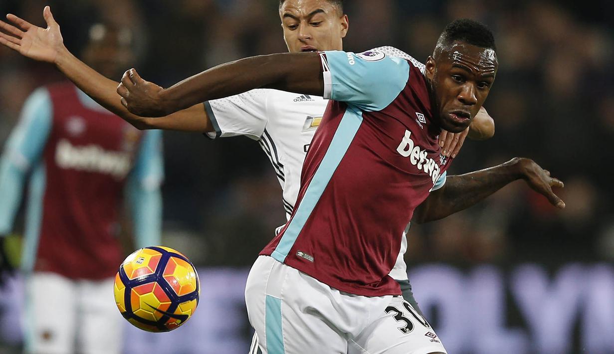 Penyerang West Ham, Michail Antonio, berebut bola dengan gelandang Manchester United, Jesse Lingard, pada laga Liga Inggris di Stadion London, Inggris, Senin (2/1/2017). West Ham kalah 0-2 dari MU. (AFP/Adrian Dennis)