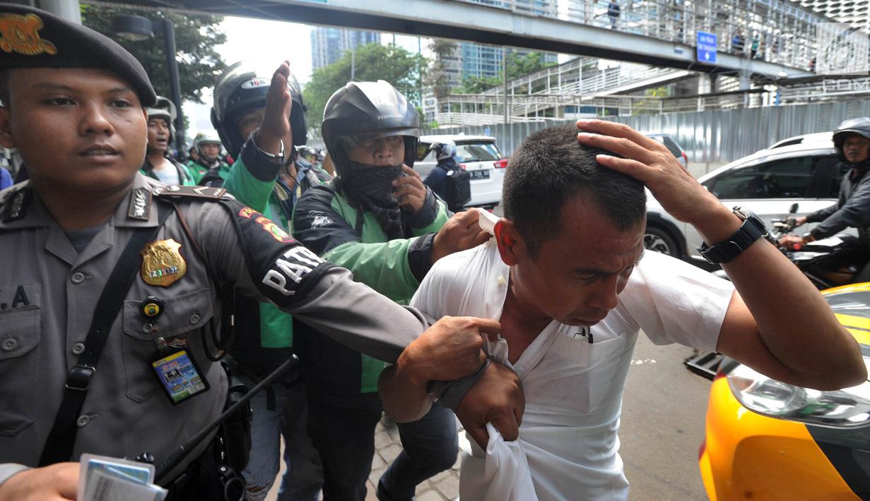 Terduga copet menutupi kepalanya dengan tangan saat akan diamankan menuju Mapolda Metro Jaya di Jalan Jenderal Sudirman, Jakarta (2/4). (Merdeka.com/Arie Basuki)