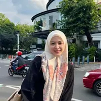 Ia memadukan sweater hitam dengan rok pastel serasi dnegan kerudung bermotifnya. [@xolovelyayana]