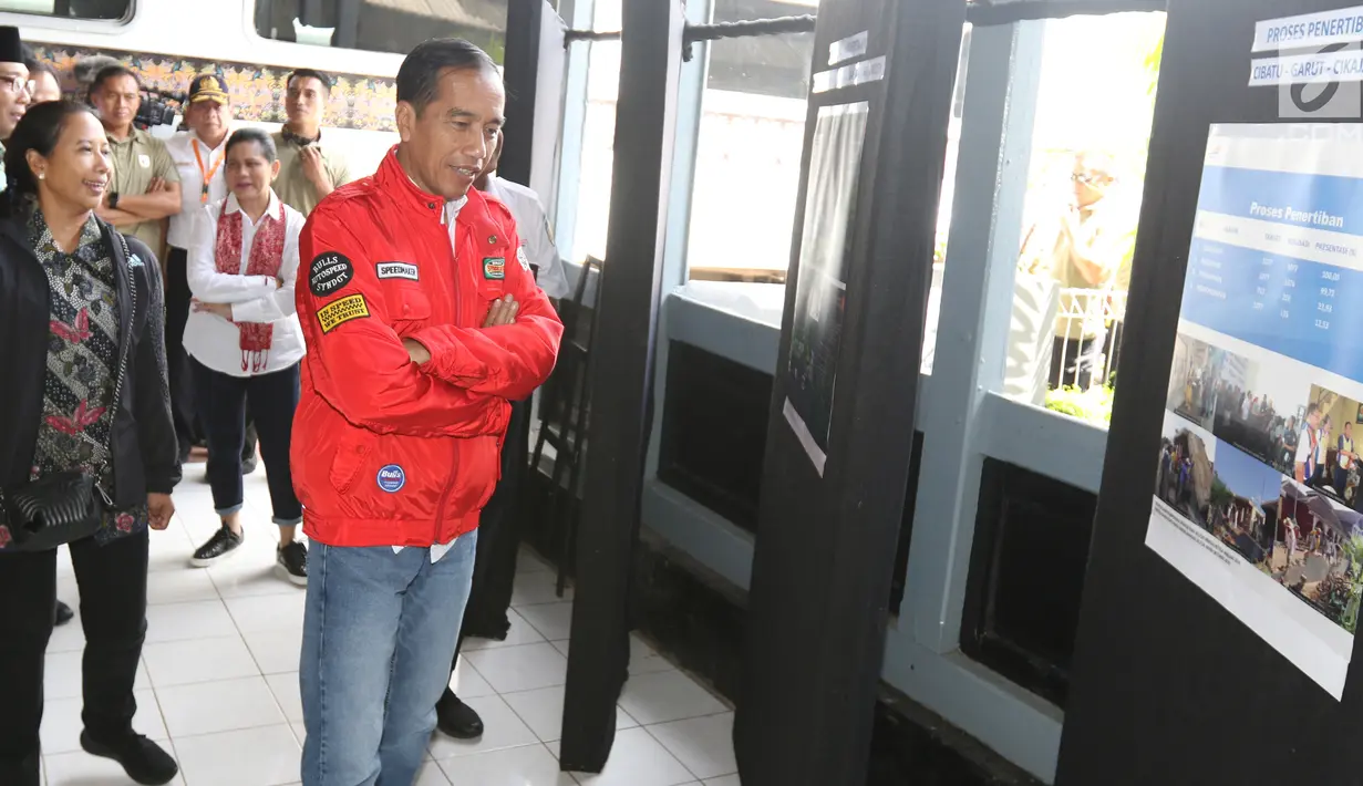 Presiden Joko Widodo melihat-lihat papan yang berisi penjelasan mengenai reaktivasi jalur kereta api di Stasiun Cibatu, Garut, Jawa Barat, Jumat (18/1). Dalam kunjungan kerja ini, Jokowi didampingi Ibu Negara Iriana Joko Widodo (Liputan6.com/Angga Yuniar)