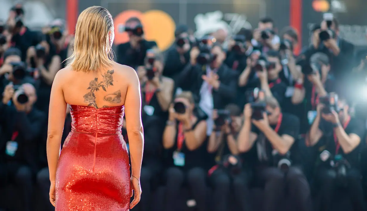 Scarlett Johansson berpose saat menghadiri pemutaran perdana film 'Marriage Story' di Venice Film Festival 2019, Italia, Kamis (29/8/2019). Bintang The Avengers itu memamerkan tato di punggungnya yang berbalut gaun merah berkilau. (Photo by Arthur Mola/Invision/AP)
