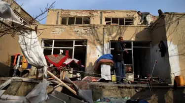 Warga menyelamatkan barang mereka dari rumah di dekat lokasi sebuah bom mobil yang meledak di sebuah restoran Prancis di Kabul, Afganistan, Sabtu (2/1/2016). Akibatnya, dua orang tewas dan 15 lainnya luka-luka. (AFP PHOTO/Wakil Kohsar)